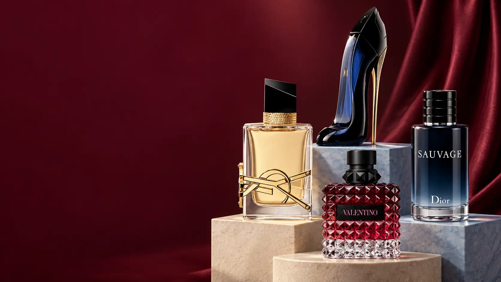 Yves Saint Laurent Libre, Carolina Herrera Good Girl, Dior Sauvage and Valentino perfumes in a burgundy still life